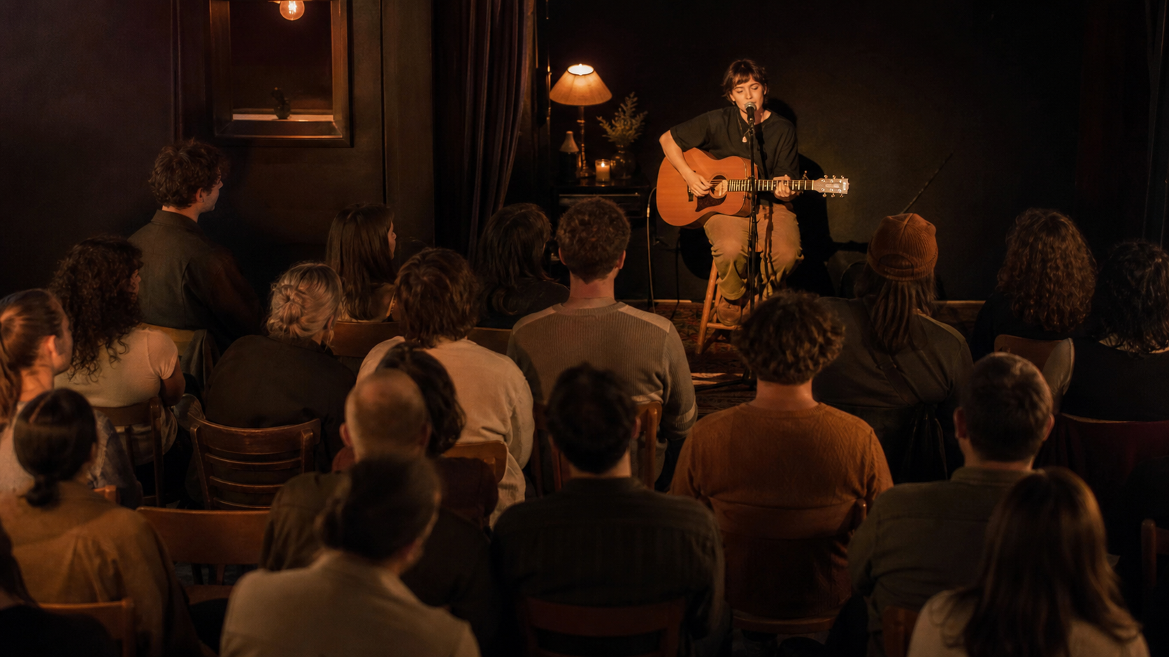 A singer performing with an acoustic guitar in an intimate, warmly lit music venue